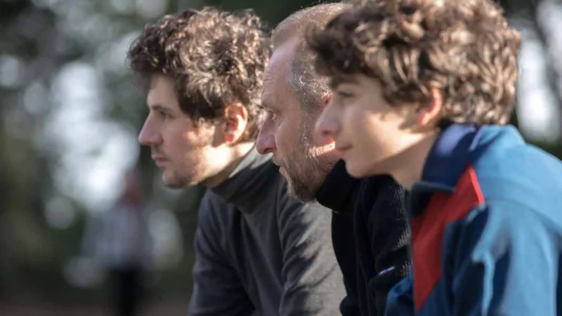 Deux Fils de Félix Moati – Benoît Poelvoorde, Vincent Lacoste et Mathieu Capella assis sur un banc