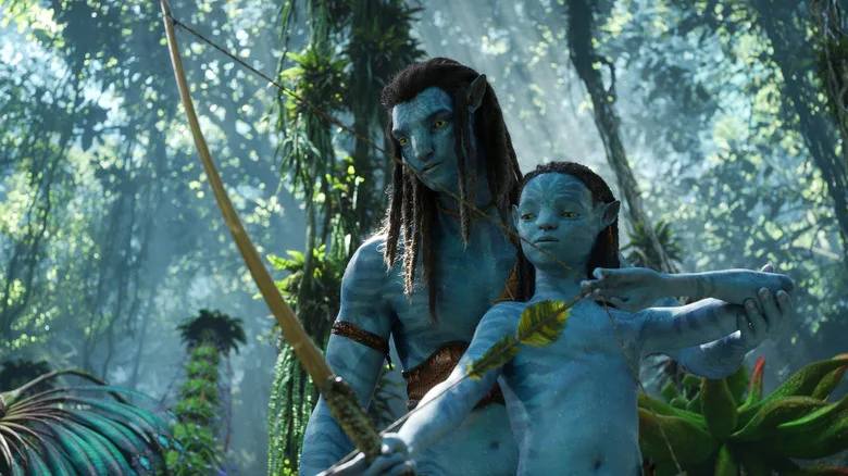 Jake Sully et un enfant Na’vi dans la forêt de Pandora dans Avatar : La Voie de l’eau