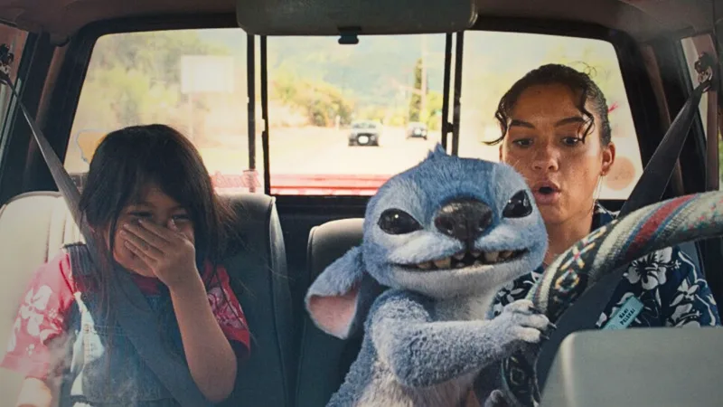 Scène du film Lilo & Stitch sur Disney+ : Stitch et une enfant dans un véhicule, décor tropical