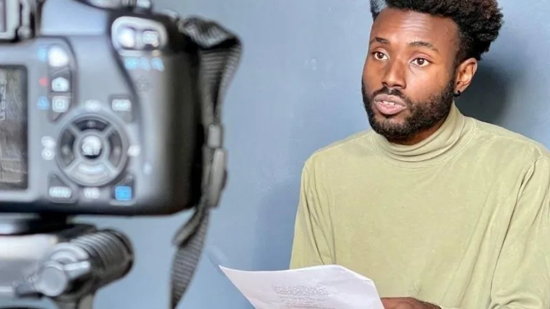 Acteur tenant un script pendant une audition filmée devant un fond neutre