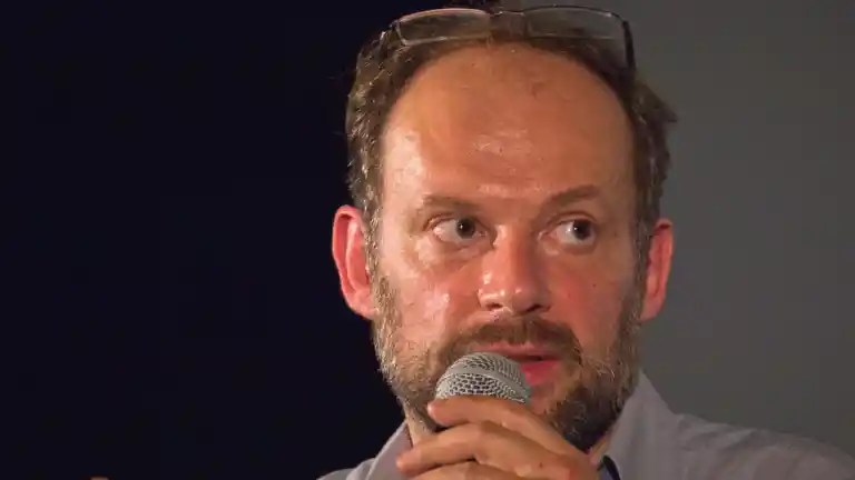 Denis Podalydès tenant un microphone lors d’une rencontre de cinéma