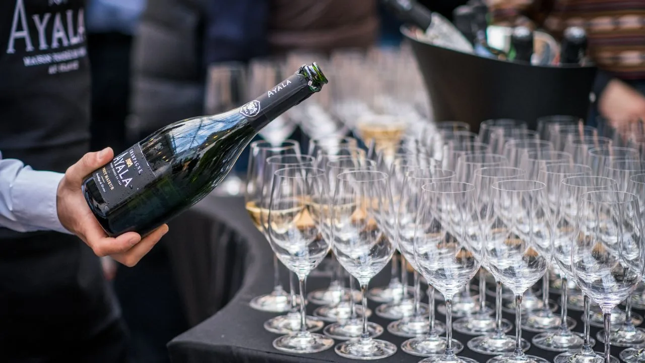 Professionnel du service versant du champagne dans une rangée de verres à Paris