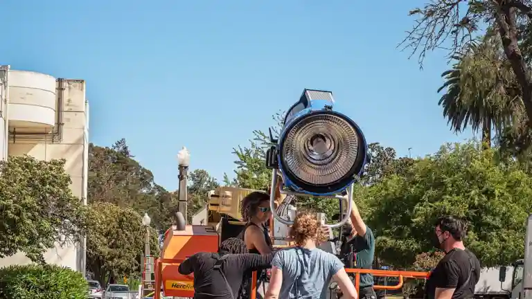 Équipe de tournage installant un projecteur de cinéma en extérieur