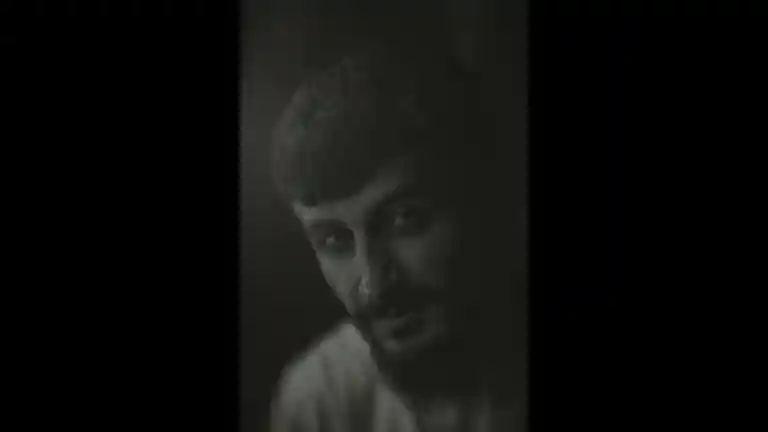 Portrait en noir et blanc d’un homme aux cheveux courts et barbu