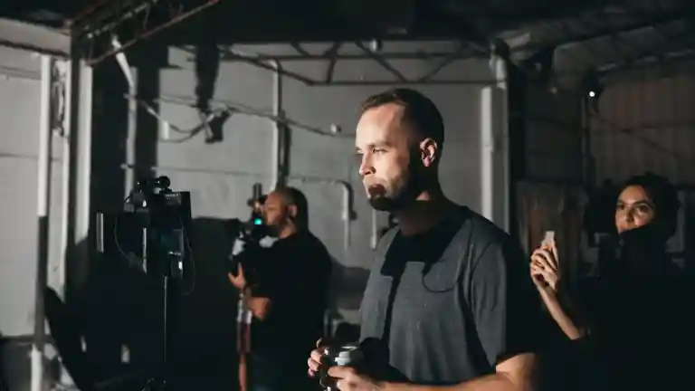 Équipe de tournage réglant une caméra et des éclairages en studio