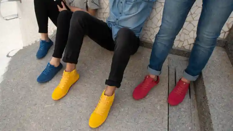 Trois personnes portant des chaussures colorées dans un décor urbain