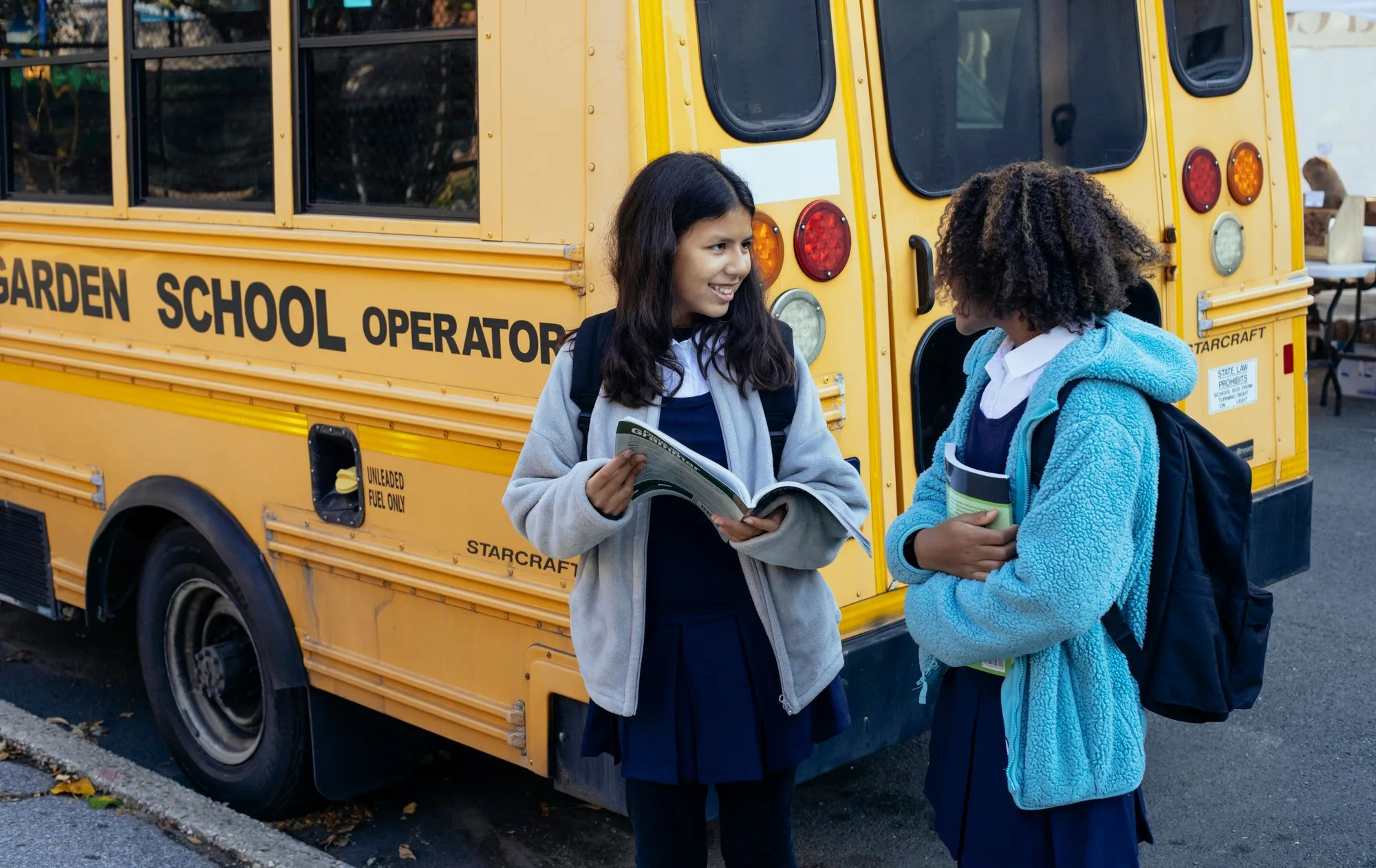 Deux jeunes filles devant un autobus scolaire