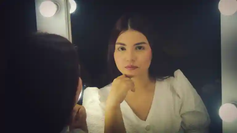 Comédienne devant un miroir de loge, illustration d’un rôle principal dans un drame psychologique.