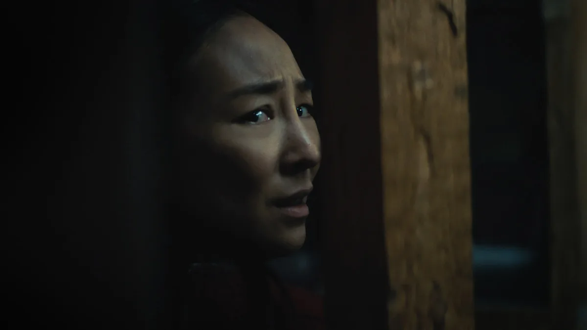 Une femme de profil dans une scène sombre du film