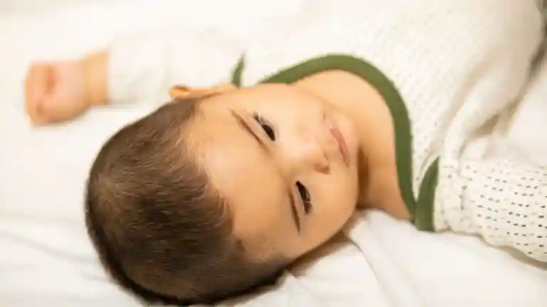 Bébé garçon aux cheveux châtains allongé