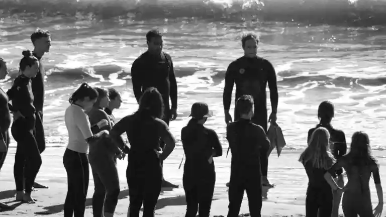 Groupe de surfeurs sur une plage pour illustrer le casting de la série Orage