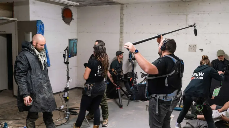 Équipe de cinéma réunie autour d'une caméra et d'une perche son pendant un tournage
