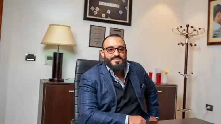 Homme barbu en costume, assis dans un bureau