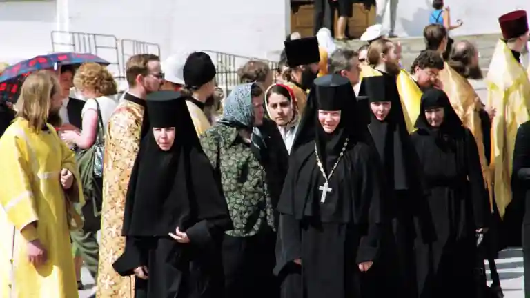 Groupe de femmes en habits religieux noirs lors d'une procession