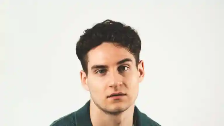 Portrait d’un jeune homme brun aux cheveux courts sur fond clair
