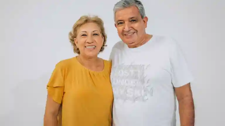 Femme et homme seniors souriants devant un fond clair