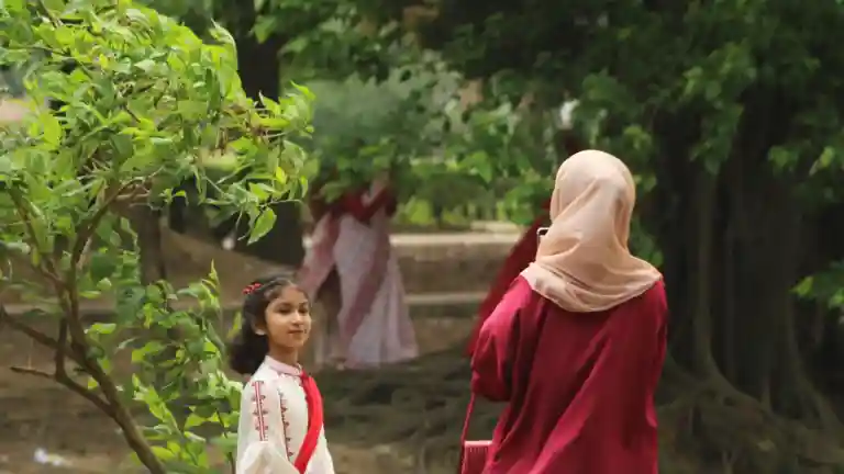 Petite fille dans un parc à côté d'une femme