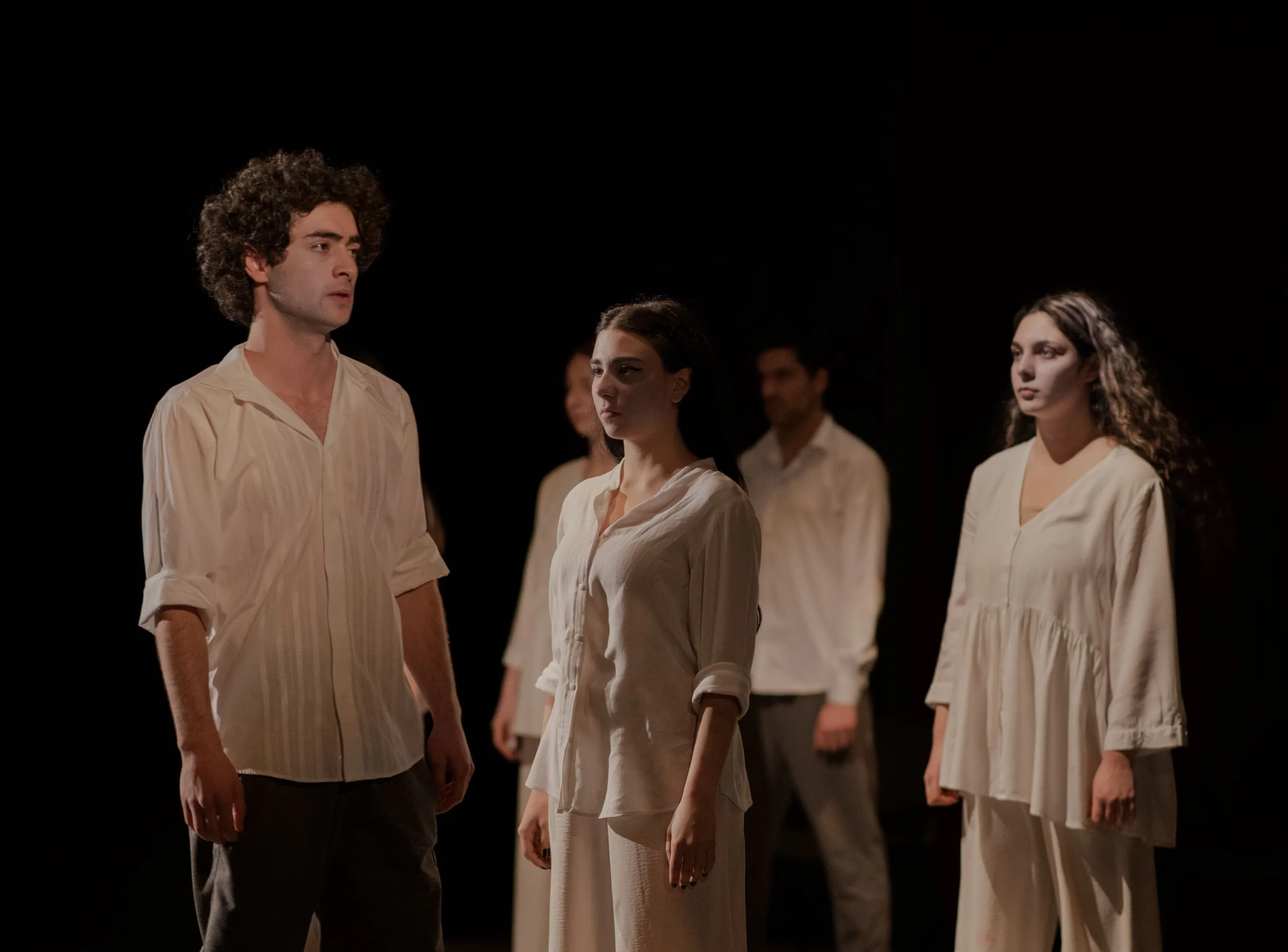 Ensemble de comédiens jouant sur une scène de théâtre