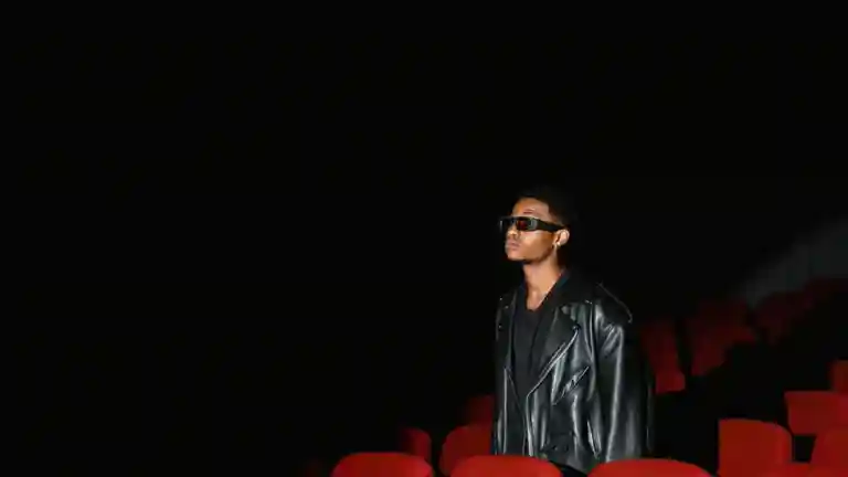 Jeune comédien debout dans une salle de cinéma