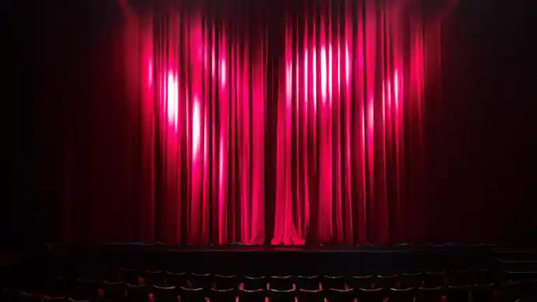 Rideau rouge éclairé sur une scène de théâtre vide