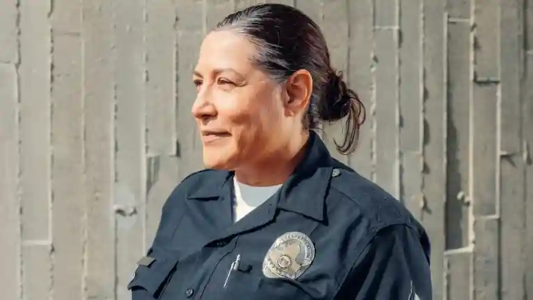 Femme policière en uniforme sombre en extérieur, photographie illustrative