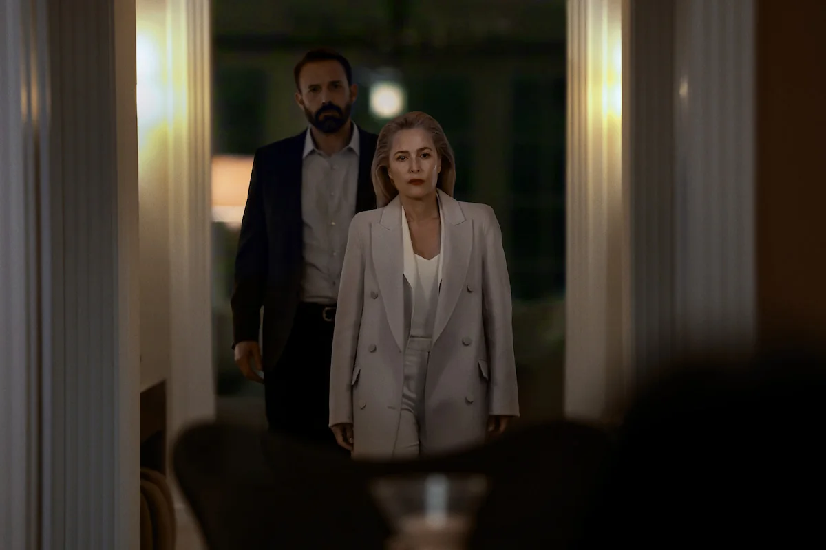 Un homme et une femme dans un couloir sombre entre deux colonnes blanches