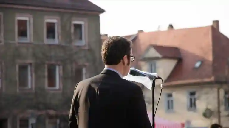 Homme en costume prenant la parole au microphone