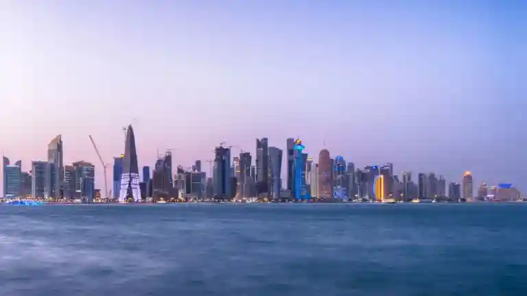 Panorama de Doha au coucher du soleil, immeubles modernes éclairés en bord de mer
