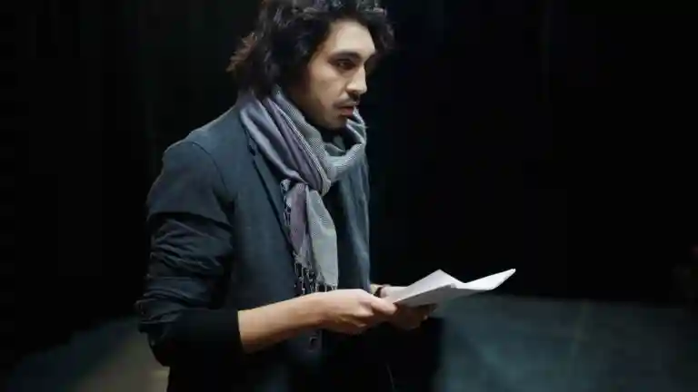 Comédien lisant un texte sur une scène de théâtre