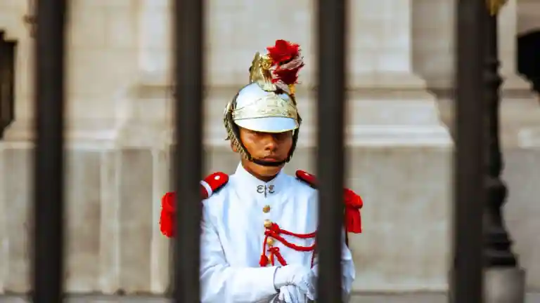 Homme portant un uniforme cérémoniel devant un édifice officiel