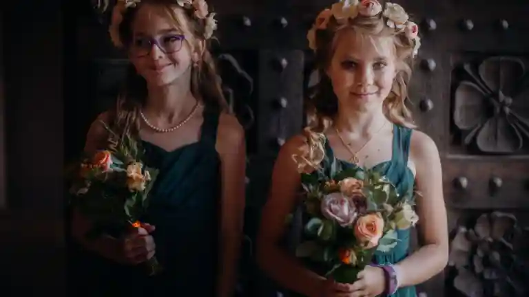 Deux jeunes demoiselles d'honneur en robes de cérémonie tenant des bouquets de fleurs ; photographie d'illustration