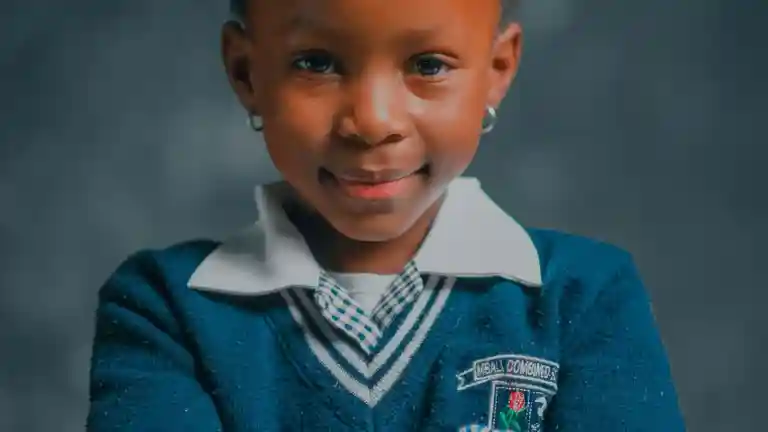 Portrait d’une enfant souriante en uniforme scolaire bleu