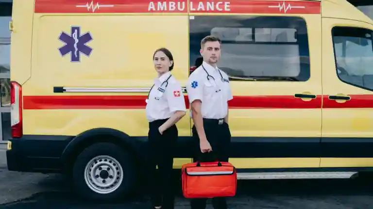 Deux membres du personnel ambulancier se tiennent devant un véhicule d'urgence