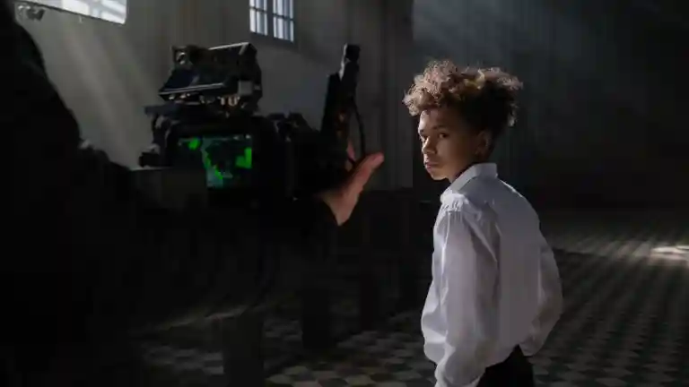 Jeune garçon interprète face à une caméra professionnelle sur un plateau de tournage