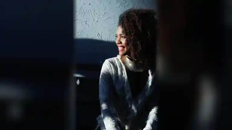 Femme souriante aux cheveux bouclés en lumière naturelle