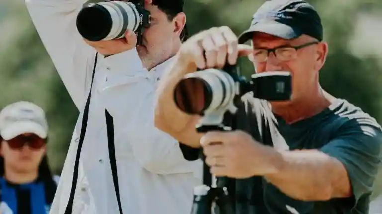 Deux photographes utilisent leurs appareils en extérieur.