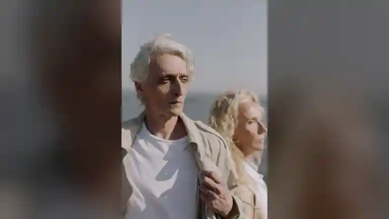 Couple senior aux cheveux gris portant des vêtements élégants, photographié près de la mer