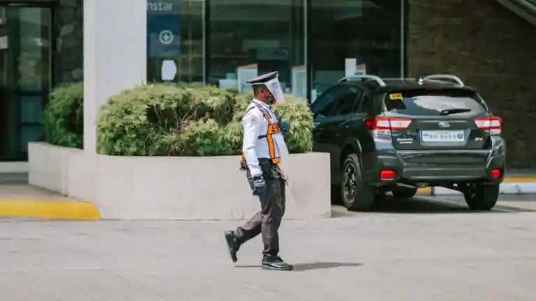 Agent de sécurité en uniforme et gants près d'un bâtiment