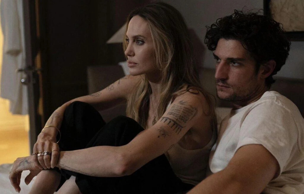 Angelina Jolie et Louis Garrel assis côte à côte dans Coutures