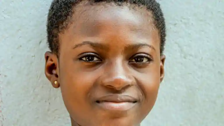 Portrait d’un enfant souriant devant un mur clair