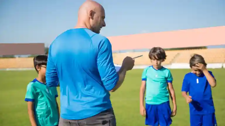 Jeunes joueurs de football avec leur entraîneur sur un terrain