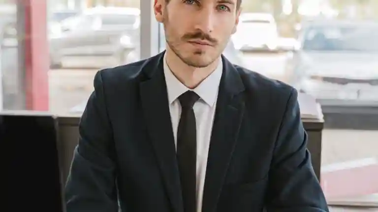 Homme d'affaires en costume noir assis à un bureau