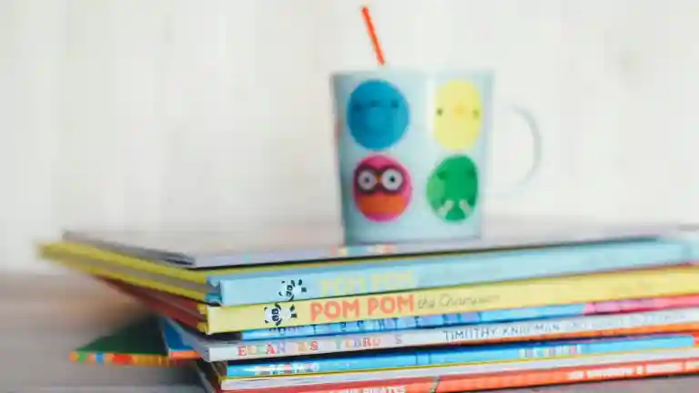 Livres illustrés empilés, photographie évoquant un personnage de fillette réfléchie