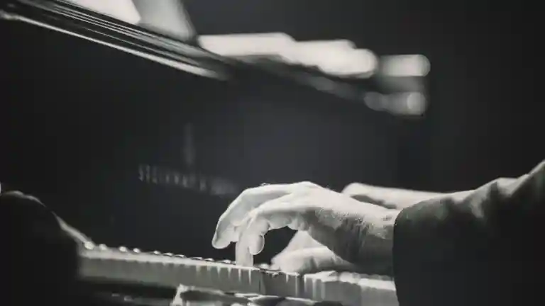 Mains jouant du piano sur un clavier, illustration des compétences musicales demandées pour Pilette