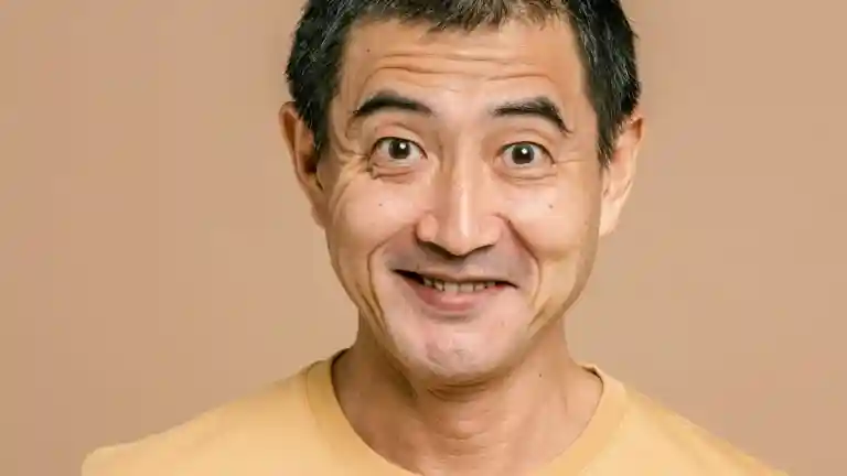 Portrait souriant d’un homme adulte aux cheveux foncés sur fond clair