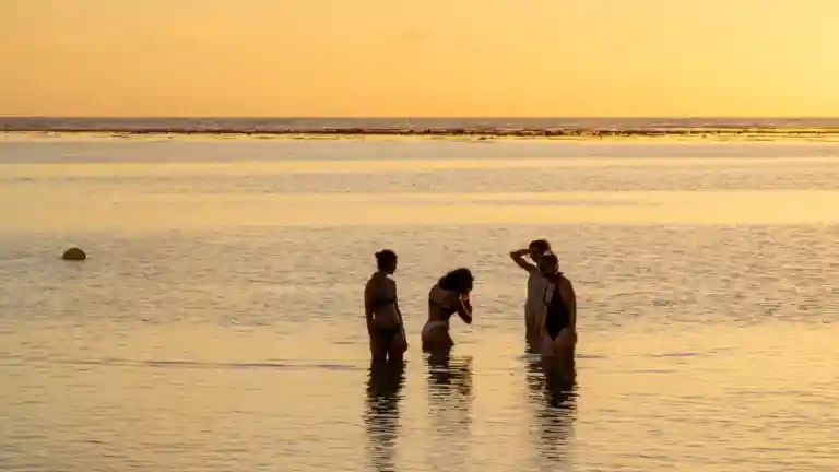 Groupe d’amis dans l’eau à La Réunion au coucher du soleil