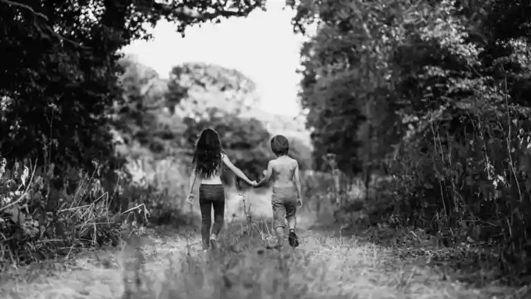 Deux enfants marchant ensemble en se tenant la main, illustration d'un lien fraternel