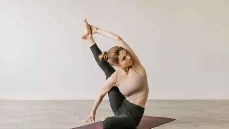 Femme réalisant une posture de yoga sur un tapis